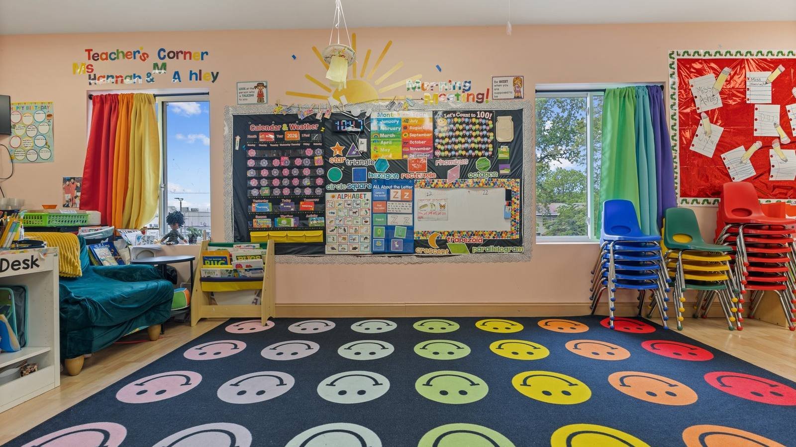 Bright Sunny Days Pre-K classroom in Cherry Hill, NJ with a smiley-face circle time rug, calendar and weather board, and stacked child-size chairs.